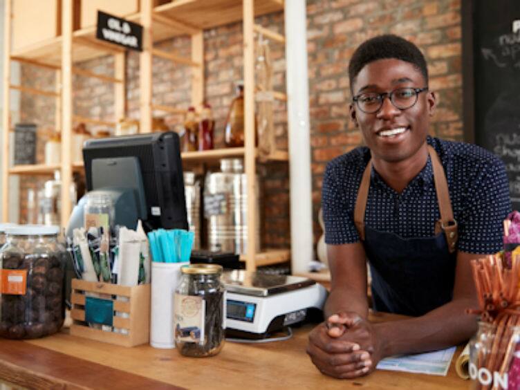 Barista leaning on a counter and smiling