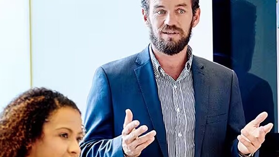 Man in business formals presenting in a meeting