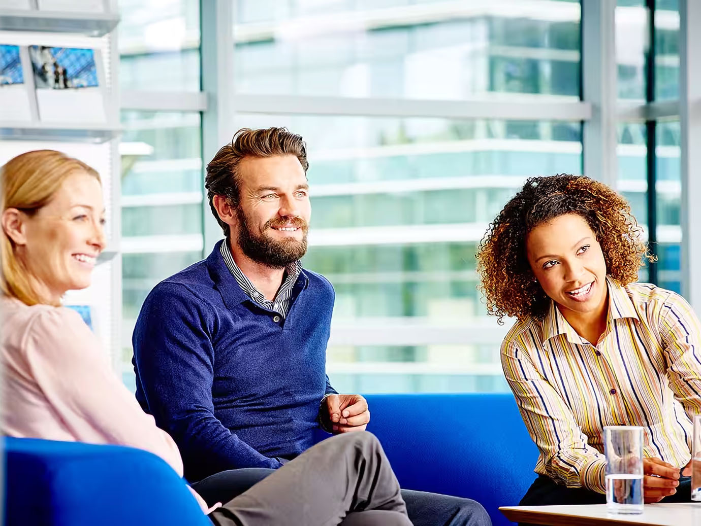 Three colleagues having a hearty conversation in office
