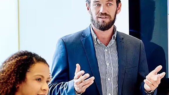 Man in business formals presenting in a meeting