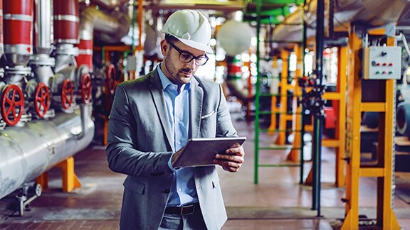 An Engineer holding a tablet in an industry environment