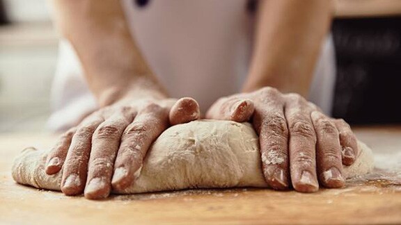 Close-up of a baker kneading dough