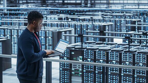 A man working on a laptop in a data center