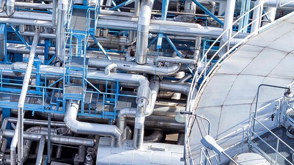 Steel pipelines and an industrial storage tank in a refinery