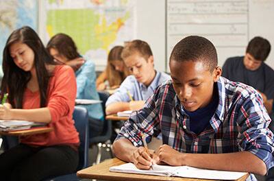 Group of students studying and taking down notes in a classroom