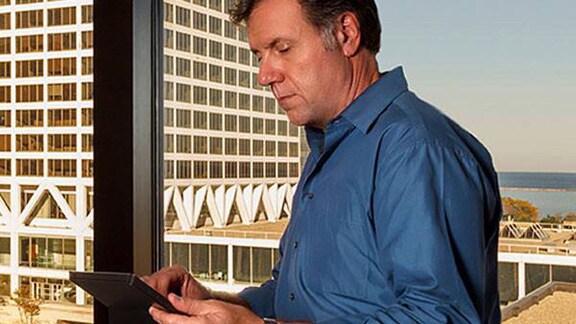 Man working on tablet beside window