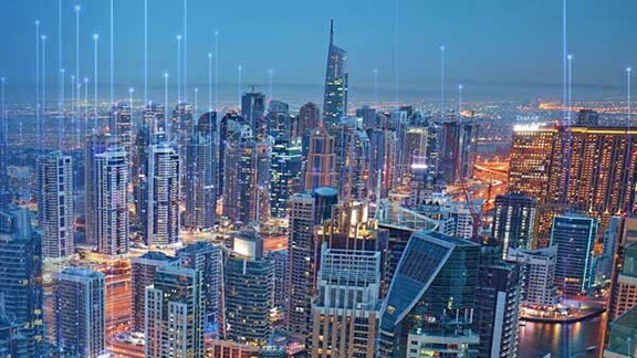 Brightly lit cityscape at nighttime overlaid with graphics of transmission nodes