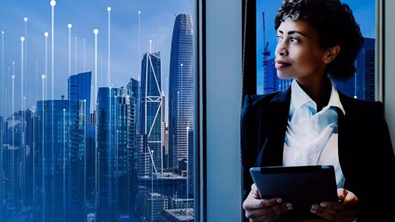 Woman looking out at the city which is overlaid with graphics of transmission node