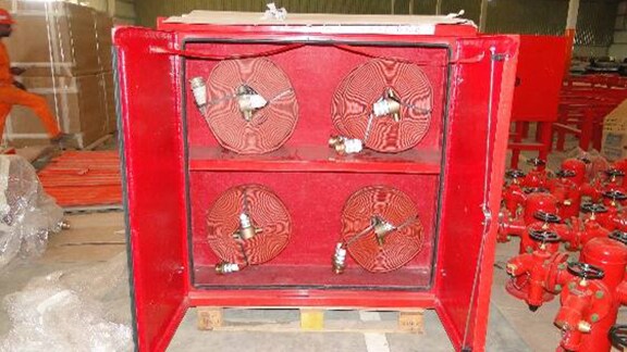 Hose cabinet containing fire hose and nozzles