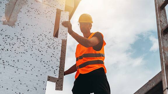 A man in safety gear fixing a wall