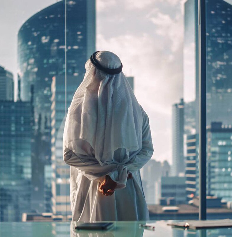 Businessman looking out of the office window at the city skyline