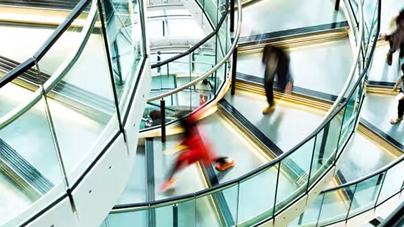 Blurry figures climbing down an office staircase