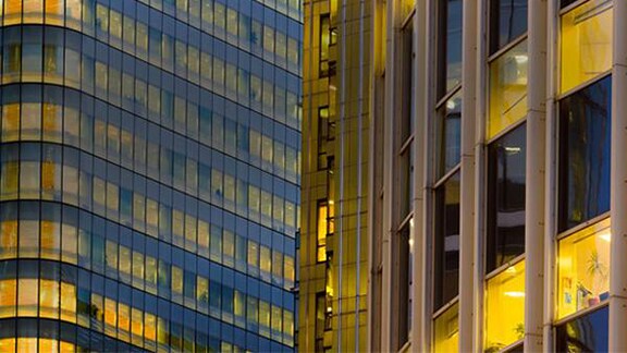Lit up windows of two office buildings