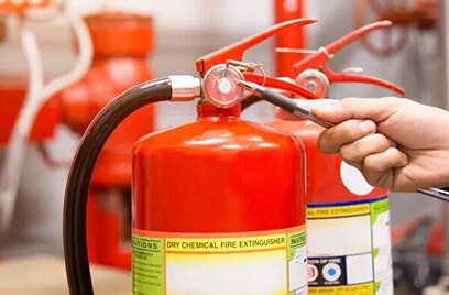 Hand marking fire extinguisher reading with a pen