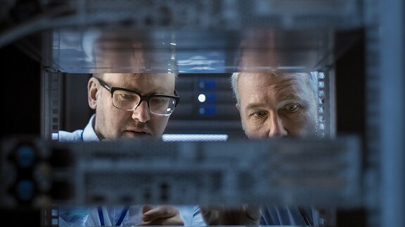 Two people implementing data backup.