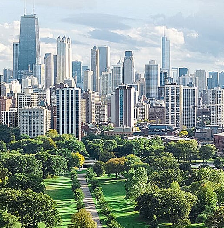 Cityscape with high-rise buildings in the background and greenery in the foreground
