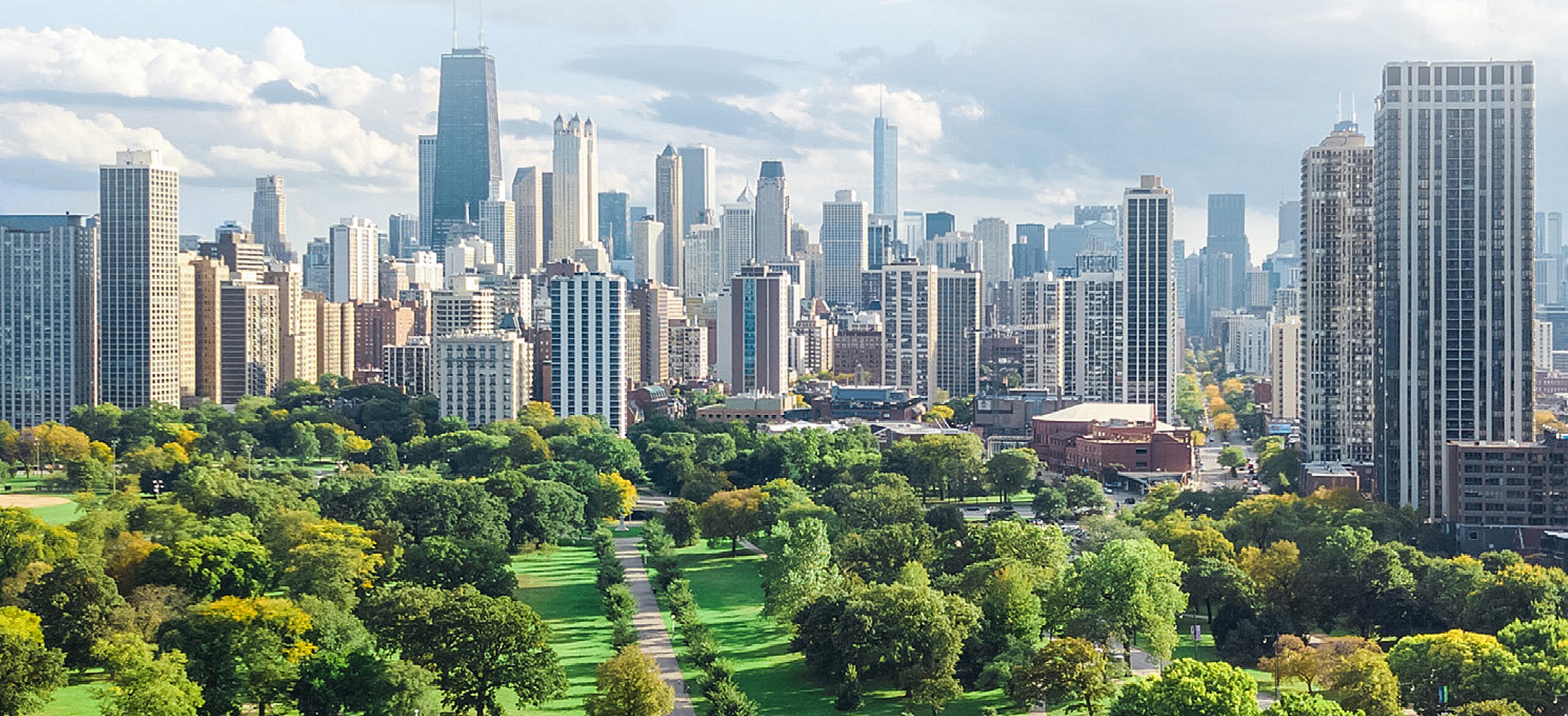 Cityscape across a lush park during a cloudy day