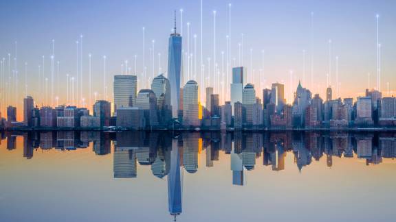 An urban skyline by a water body, at sunset