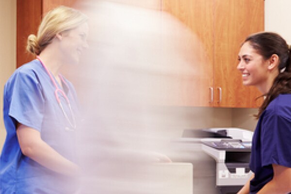 Doctors, patients and nurses walking along a hospital passage
