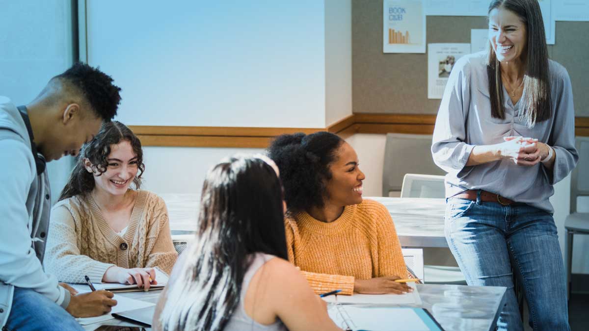 Teacher and students laughing in a classroom