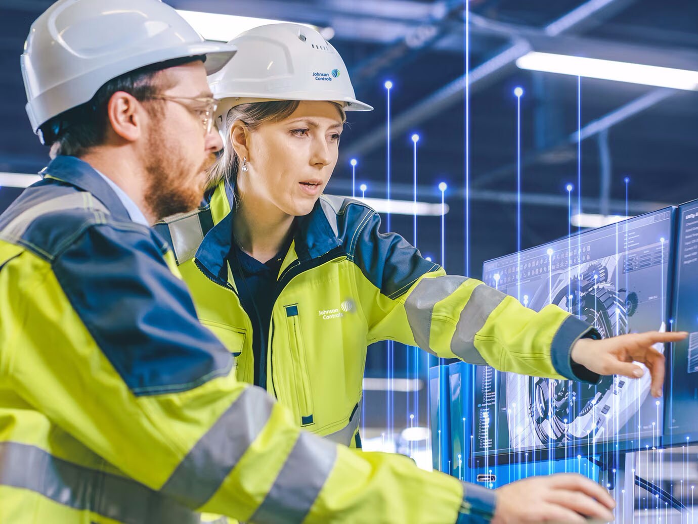 Two techinicians in safety jackets working on a desktop with an overlay of Openblue graphics