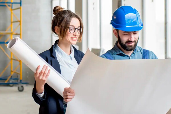 Man and woman consulting charts in a construction facility