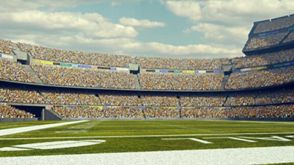 Crowded stands across a football field in a stadium