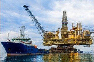 A ship and an oil rig platform in the ocean
