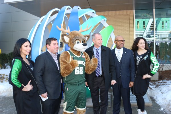 Peter Feigin, George Oliver and Grady Crosby standing with a Bucks mascot and two dancers