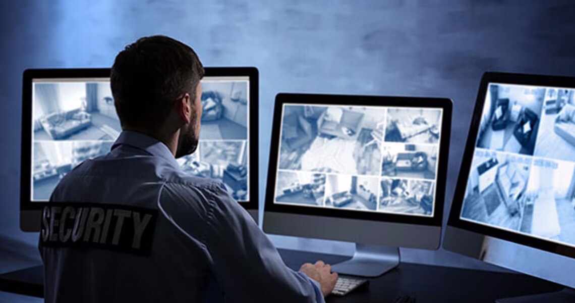 A security guard looking at surveillance footage on a monitor