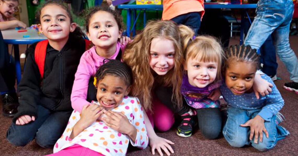 Group of children in a classroom posing for a photoraph