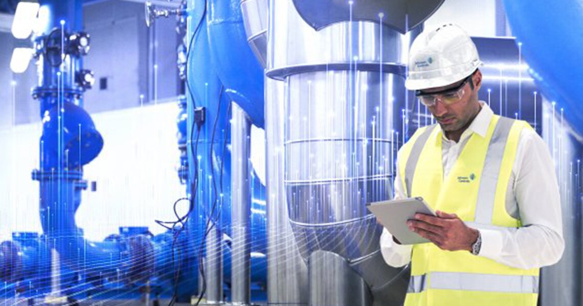 Johnson Controls technician using a tablet and inspecting HVAC equipments