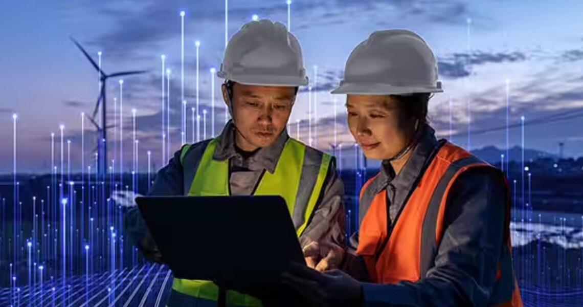 Two technicians wearing safety gear and looking at a laptop in a wind farm, surrounded by OpenBlue graphics