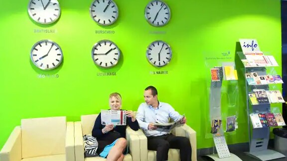 Man and a woman conversing in the lobby of a building