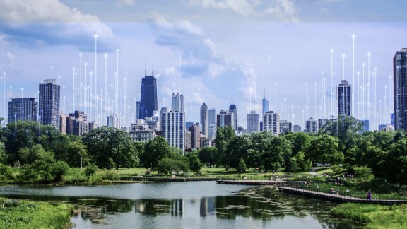 Waterfront skyline of a city, overlaid with a graphic of transmission nodes