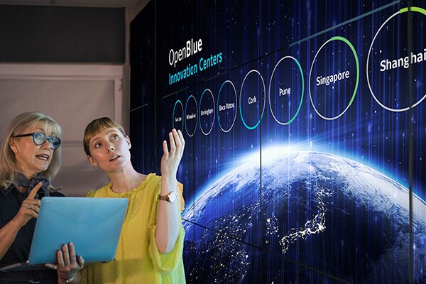 Two women discussing a presentation on OpenBlue Innovation Centers