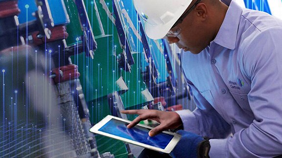 Johnson Controls technician using a tablet and inspecting HVAC equipment