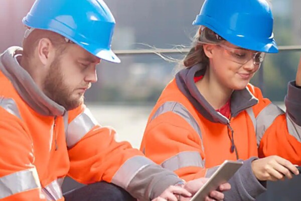 A female and male technician repairing an air conditioning unit