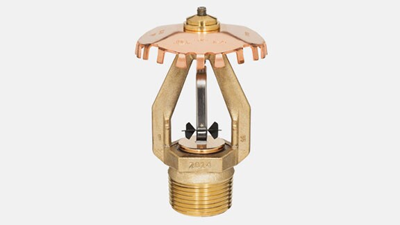 a golden sprinkler on a grey background