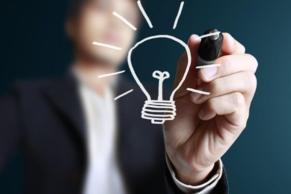 Illustration of a person sketching a glowing bulb