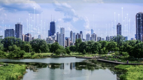 An urban skyline surrounded by greenery, with OpenBlue graphics overlaid behind