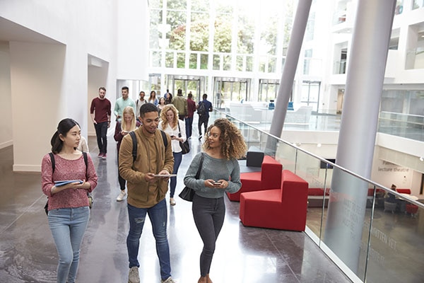 Students talking and walking through a university hallway