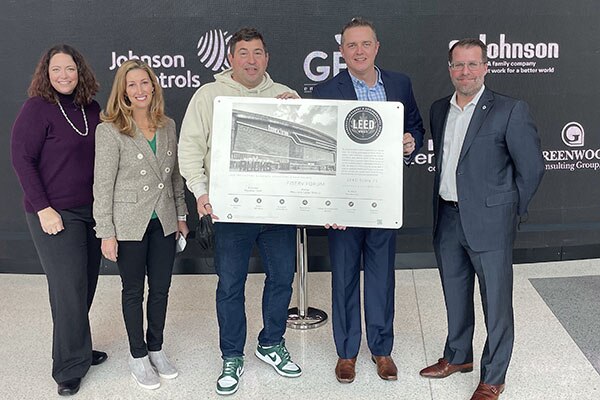 A group of people posing for a photograph with the LEED® Gold Certificate